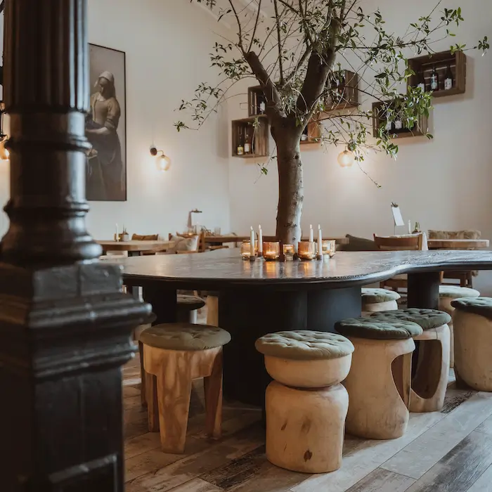Tisch mit Olivenbaum in der Mitte.